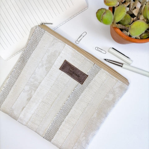 Lined zipper pouch made using strips of fabric in shades of white