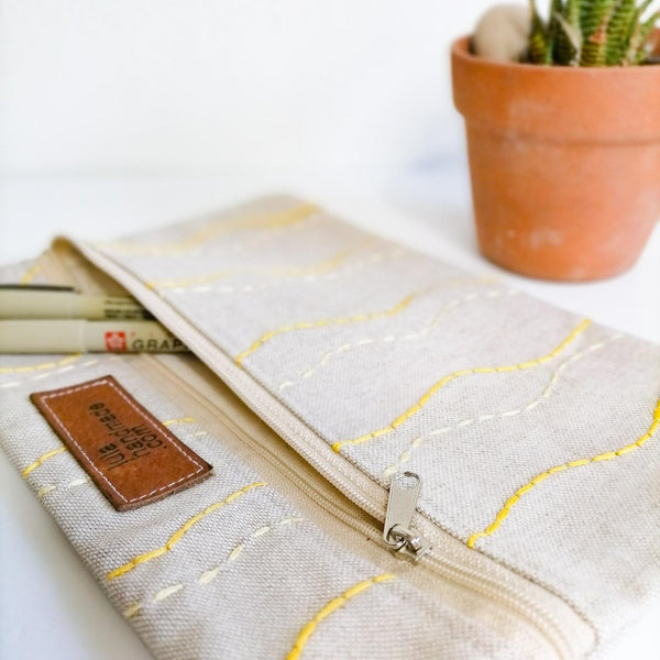 Shades of yellow wavy lines on linen zipper pouch