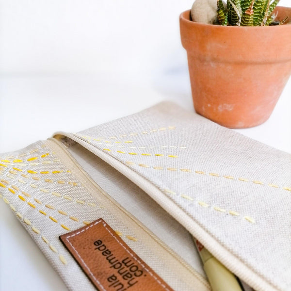 shades of yellow rays from top corner depicting sun on linen zipper pouch